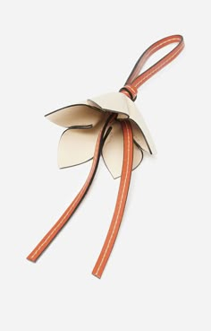 an origami flower with leather straps on a white background