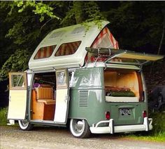 an old camper parked on the side of a road with it's door open