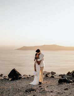 a bride and groom kissing on the beach