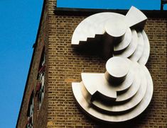 a clock on the side of a building with a blue sky in the back ground