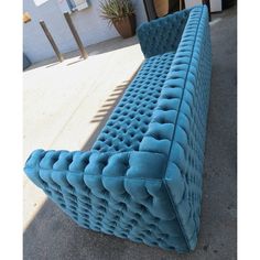 a blue couch sitting on top of a sidewalk