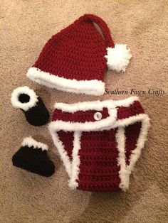 a crocheted santa hat and booties laying on the floor