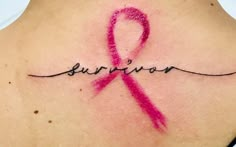 a woman's back with a pink ribbon and the word survivor written in cursive writing