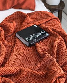 an orange blanket with a black book on it