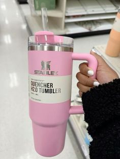 a person holding a pink tumbler cup in their hand