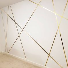 a white room with gold lines on the wall