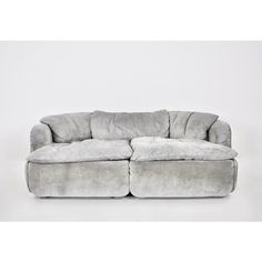 a grey couch with two pillows on it's back and one arm folded out