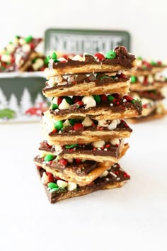 a stack of christmas crackers with chocolate and candy toppings on top, in front of a tin can