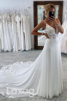 a woman is taking a selfie in front of her wedding dress while looking at her phone