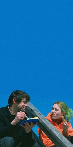 a man and woman sitting on the steps with frisbees in their hands