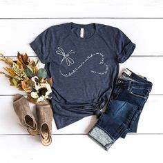 a women's t - shirt with a heart and flowers on it next to some jeans