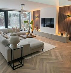 a modern living room with wood flooring and large windows