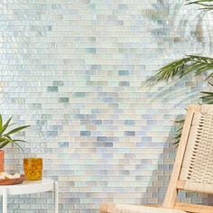 a chair sitting next to a table with plants on it and a potted plant in front of the wall