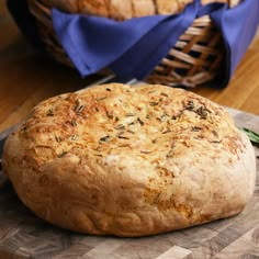 a loaf of bread sitting on top of a wooden cutting board next to a basket