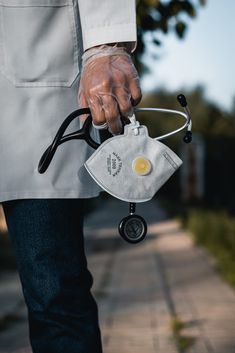 a person in white jacket holding a small bag with an egg on it's handle