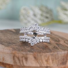 two wedding rings sitting on top of a wooden board