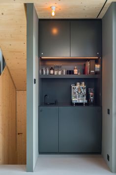 a kitchen area with cabinets and shelves in the wall, along with an espresso machine