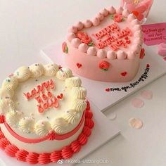 two decorated birthday cakes sitting on top of each other in front of a white table