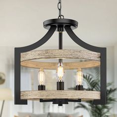 a chandelier with three lights hanging from it's center and wood accents