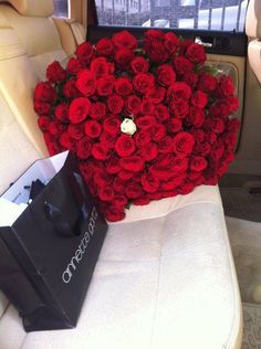 a large bouquet of red roses in the back seat of a car