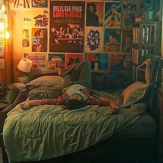 a person laying on top of a bed in a room filled with posters and lights