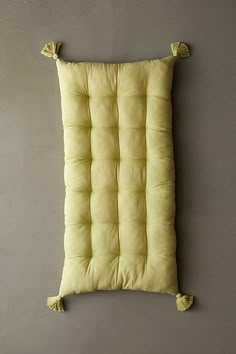 a yellow cushion hanging on the wall