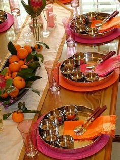 the table is set with oranges and silverware for an elegant dinner or brunch