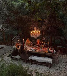 people sitting at a table with candles in front of them and the words, the forest setting