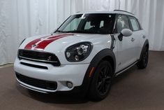 the front end of a white and red mini countryman parked in a showroom