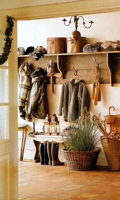 a room filled with lots of coats hanging on the wall next to a potted plant