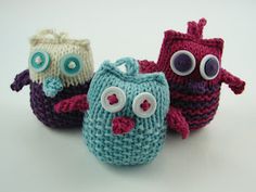 three crocheted owls sitting next to each other on a white surface with eyes