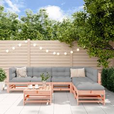 a couch and coffee table sitting on top of a white tile floor next to a wooden fence