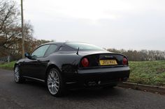 a black sports car is parked on the side of the road