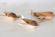 three wooden toy airplanes on a white surface