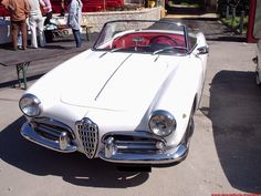 an old white convertible car parked on the street