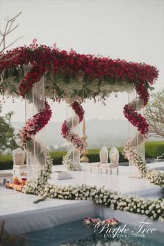 an outdoor wedding setup with flowers on the table and chairs in the back drop off area