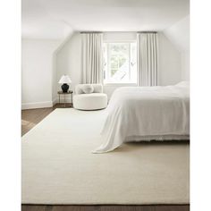 a bedroom with white walls and carpeted flooring, along with a bed in the corner