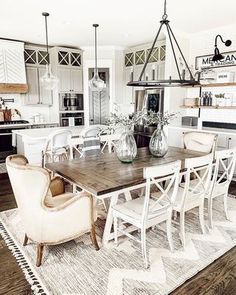 a dining room table with chairs and vases on top of it in a kitchen