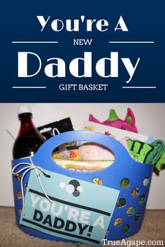 a blue basket filled with items that says, you're a new daddy gift basket