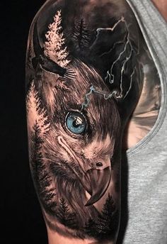 a man's arm with an eagle and trees on it