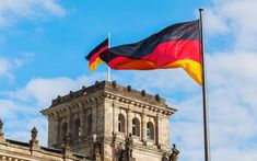 the german flag is flying in front of an old building