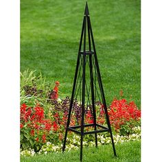 a tall black metal plant stand in the grass