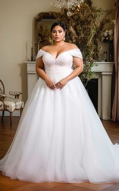 a woman in a white wedding dress posing for the camera with her hands on her hips