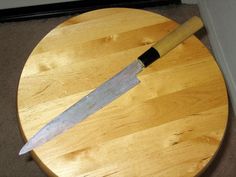 a wooden table with a large knife on it's side and a door in the background