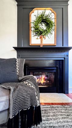 a living room with a fire place and a wreath on the fireplace mantel above it