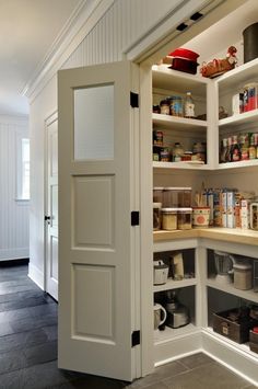 an open pantry door in the middle of a room with shelves and other items on it