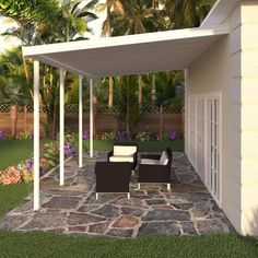 a covered patio with two chairs and a table in the grass next to some trees