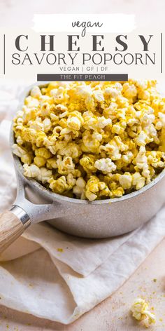 vegan cheesy savory popcorn in a bowl with a wooden spoon