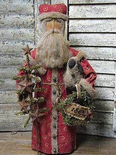 a santa claus figurine holding a teddy bear