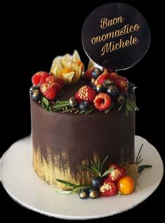 there is a chocolate cake with berries on the top and an inscription in spanish above it